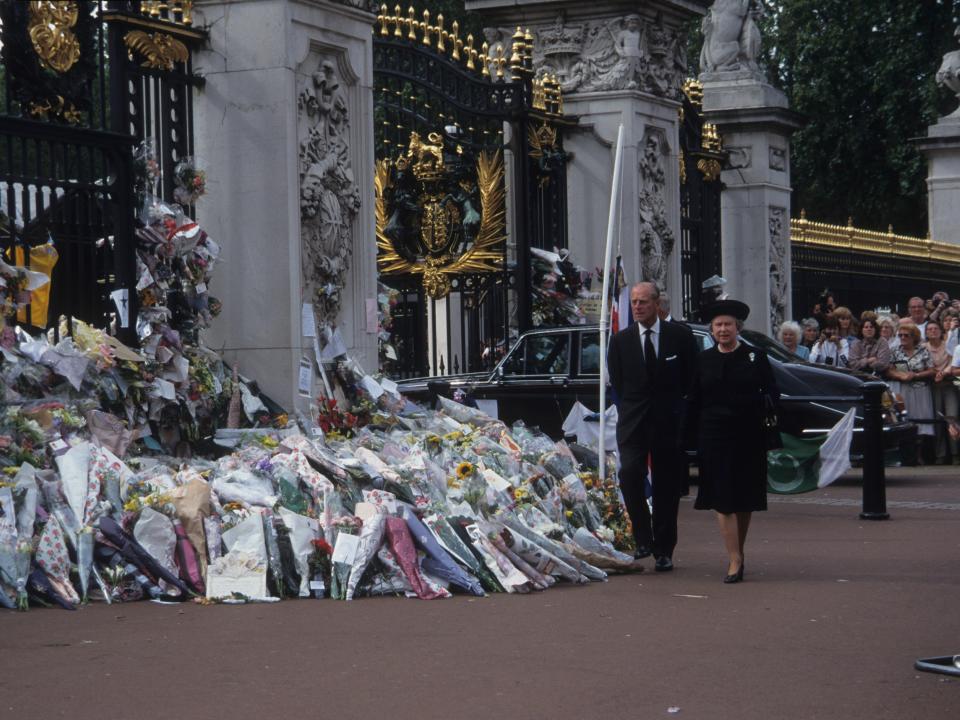 Queen Elizabeth and Prince Philip walk past the gates of Buckingham Palace during the public funeral of Diana, Princess of Wales, on September 6, 1997