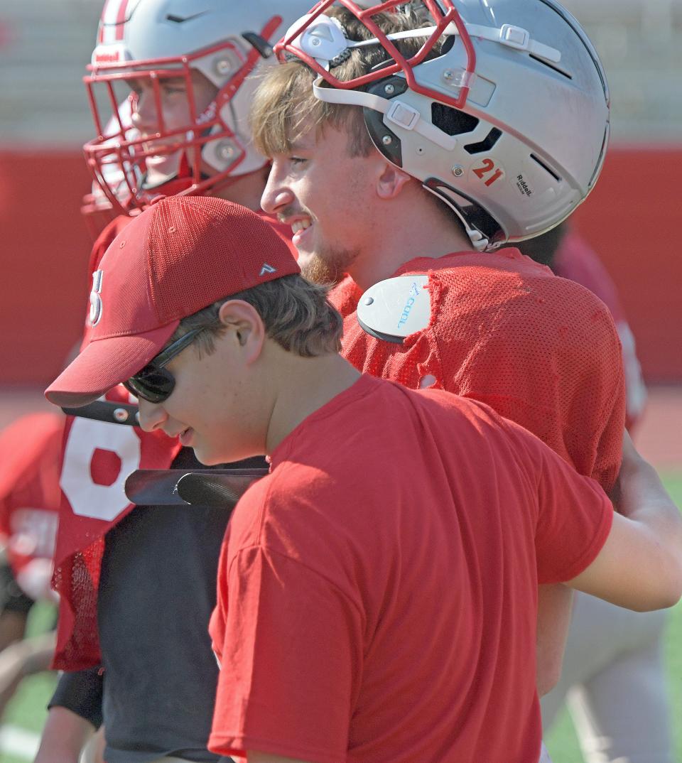 Alex Bushey encourages a member of the team Wednesday afternoon during Shelby Whippet football practice.