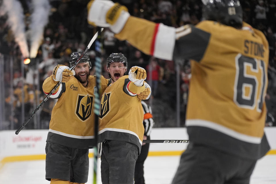 Vegas Golden Knights center Jack Eichel, center, and right wing Mark Stone, right, celebrate with defenseman Alex Pietrangelo, left, after Pietrangelo scored against the Boston Bruins during overtime of an NHL hockey game Thursday, Jan. 11, 2024, in Las Vegas. (AP Photo/John Locher)