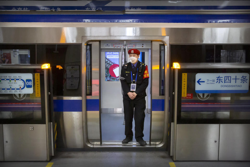 FILE - In this Feb. 3, 2020, file photo, a security officer wearing a face mask stands on a subway train in Beijing. Health authorities are preparing for a possible pandemic as they work to contain a respiratory illness in China that's caused by a new virus. Governments are working to contain the virus by limiting travel, isolating sick people and keeping travelers returning from the affected region under quarantine to watch for symptoms. (AP Photo/Mark Schiefelbein, File)