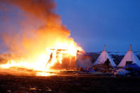 <p>A building burns after it was set on fire by protesters at the main opposition camp against the Dakota Access oil pipeline, near Cannon Ball, N.D., Feb. 22, 2017. (Photo: Terray Sylvester/Reuters) </p>