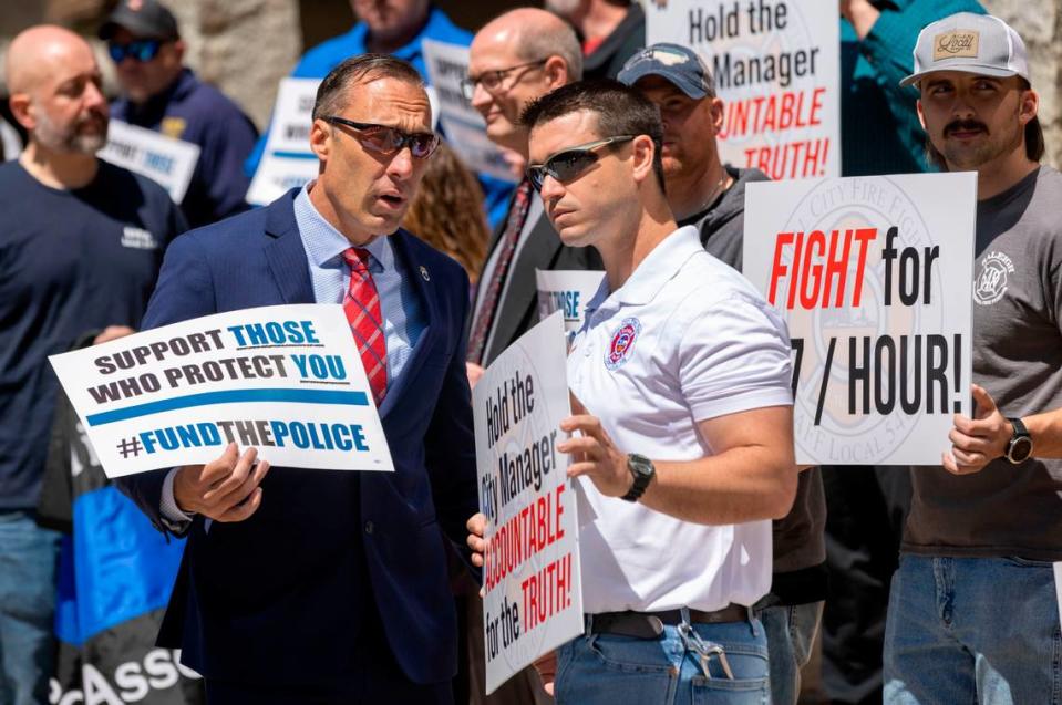 Rick Armstrong from Teamsters Local 391, left, and Andrew Davis, of the Raleigh Professional Firefighters Association, demonstrate for high wages for Raleigh police and firefighters on Tuesday, April 19, 2022 in Raleigh, N.C.