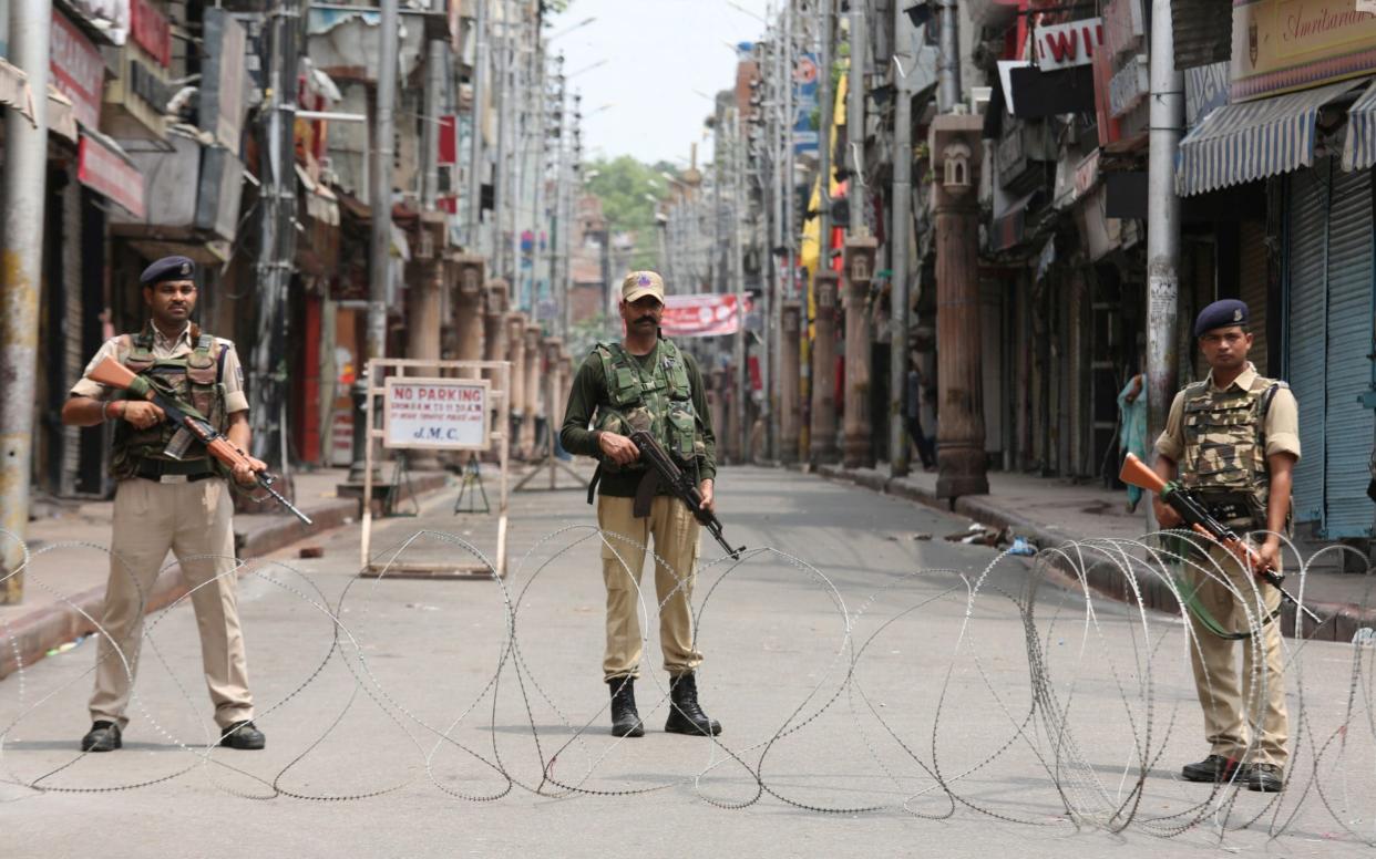 Indian security personnel stand guard along a deserted street during restrictions in Jammu, August 5, 2019 - REUTERS