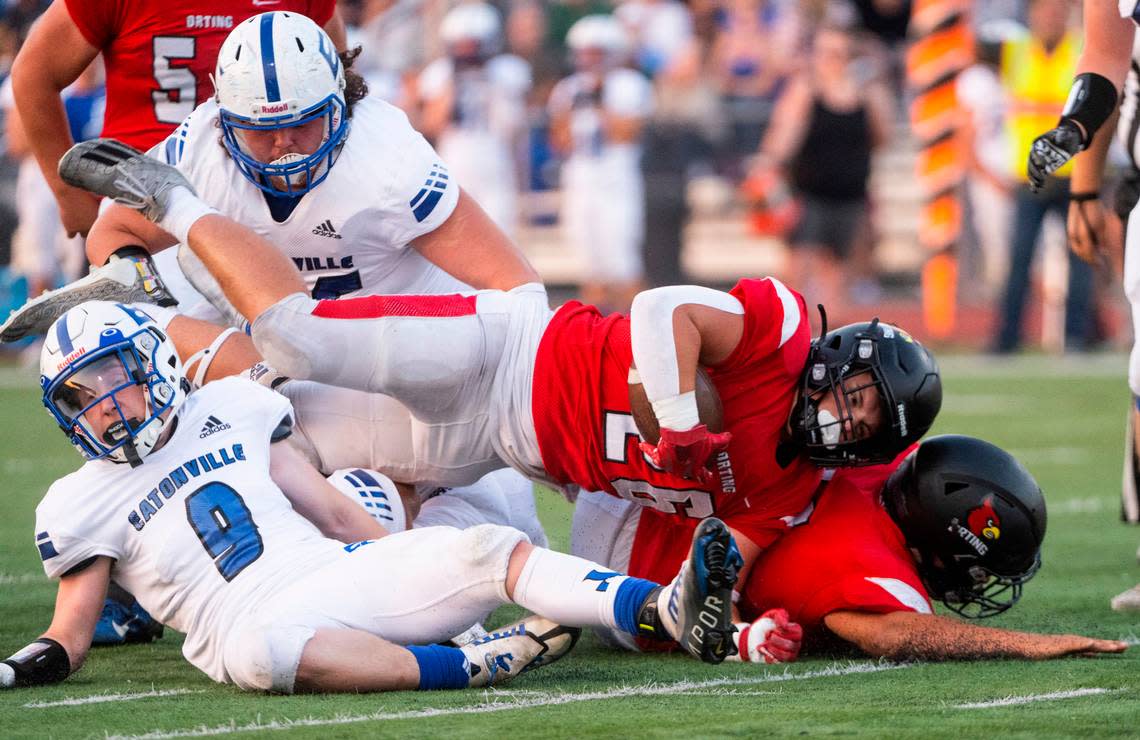 Orting running back Whyatt Phelan (26) trips over Eatonville defensive back Riley Hill (9) while running the ball down the field during the first quarter of a Friday night game at Orting Stadium in Orting Wash. on Sept. 9, 2022.