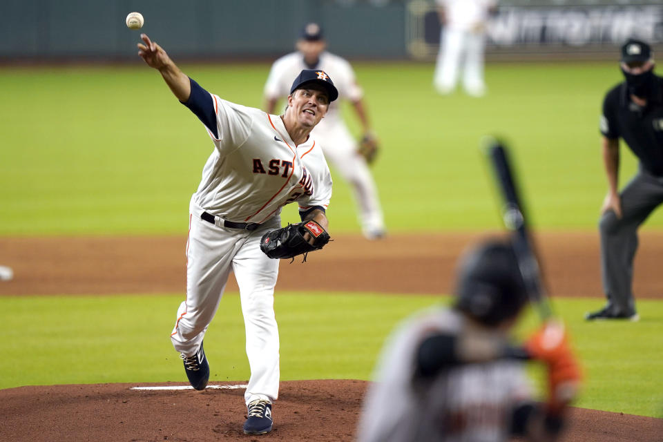 Houston Astros starting pitcher Zack Greinke, left, throws to San Francisco Giants' Wilmer Flores during the first inning of a baseball game Wednesday, Aug. 12, 2020, in Houston. (AP Photo/David J. Phillip)