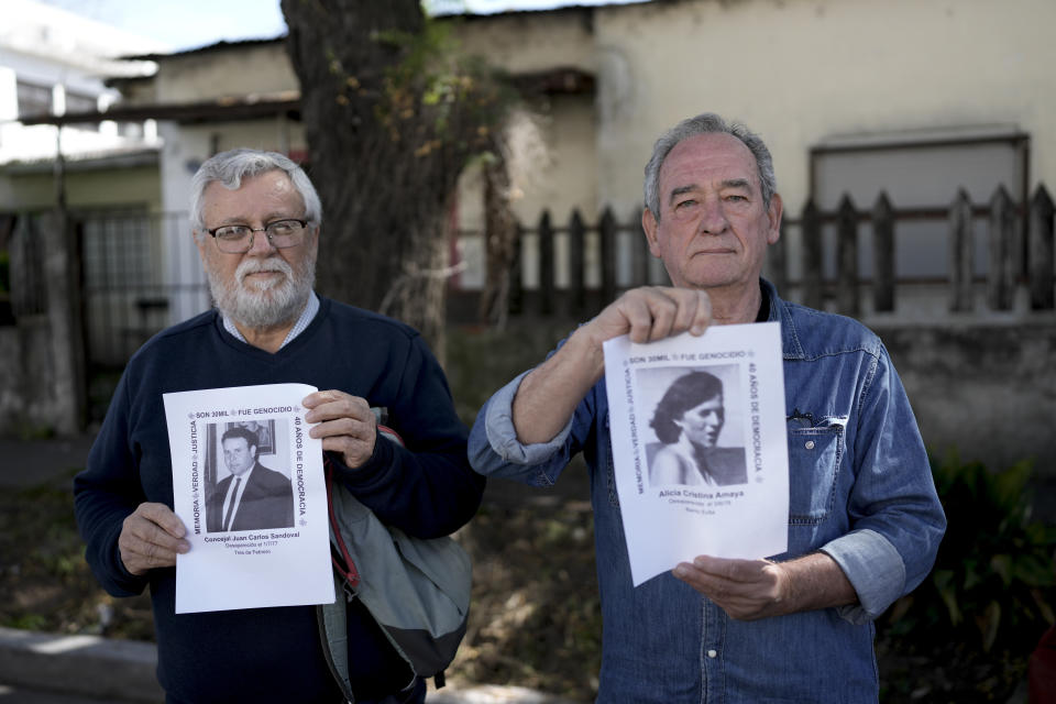 Edgardo Fontana, izquierda, posa con una fotografía de su pariente Carlos Sandoval, junto a Horacio Amaya, quien sostiene una foto de su hermana Alicia Cristina Amaya, ambas desaparecidas durante la última dictadura militar de Argentina, afuera de un colegio electoral durante la segunda vuelta presidencial entre Javier Milei y Sergio Massa en las afueras de Buenos Aires, Argentina, domingo 19 de noviembre de 2023. (Foto AP/Rodrigo Abd)