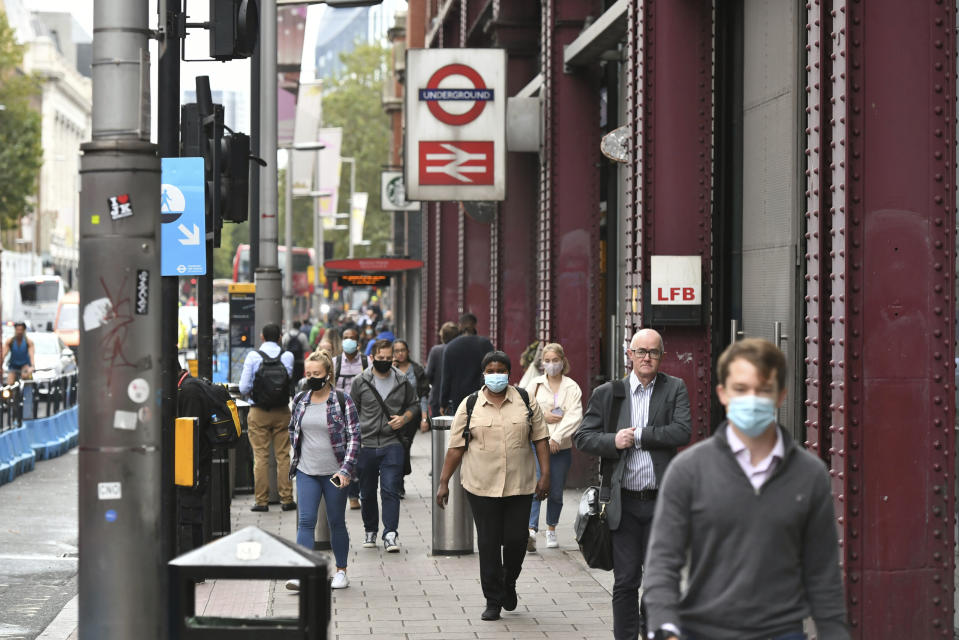 People exit Waterloo station in London, Wednesday, Sept. 23, 2020, after Prime Minister Boris Johnson announced a range of new restrictions to combat the rise in coronavirus cases in England, Wednesday, Sept. 23, 2020. (Dominic Lipinski/PA via AP)