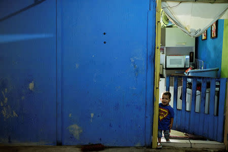 A boy stands in the entrance of a flat at the abandoned Prestes Maia textile factory occupied by a homeless movement in downtown Sao Paulo, Brazil, May 7, 2018. REUTERS/Nacho Doce