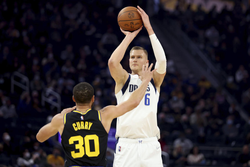 Dallas Mavericks center Kristaps Porzingis (6) shoots against Golden State Warriors guard Stephen Curry (30) during the first half of an NBA basketball game in San Francisco, Tuesday, Jan. 25, 2022. (AP Photo/Jed Jacobsohn)