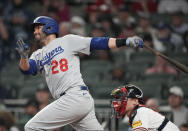 Los Angeles Dodgers designated hitter J.D. Martinez (28) follows through on a single as Atlanta Braves catcher Sean Murphy, right, looks on in the fourth inning of a baseball game, Monday, May 22, 2023, in Atlanta. (AP Photo/John Bazemore)