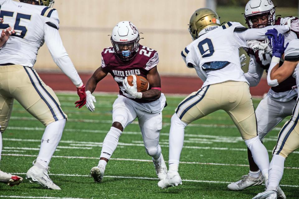 Hodgson senior Maki Beach (22) looks to run the ball past the defense by Salesianum senior Ahmaad Foster (55) and junior Lamar "LJ" Smith (9) during the football game at St. Georges High football stadium in Middletown, Saturday, Nov. 4, 2023. Salesianum won 38-19.