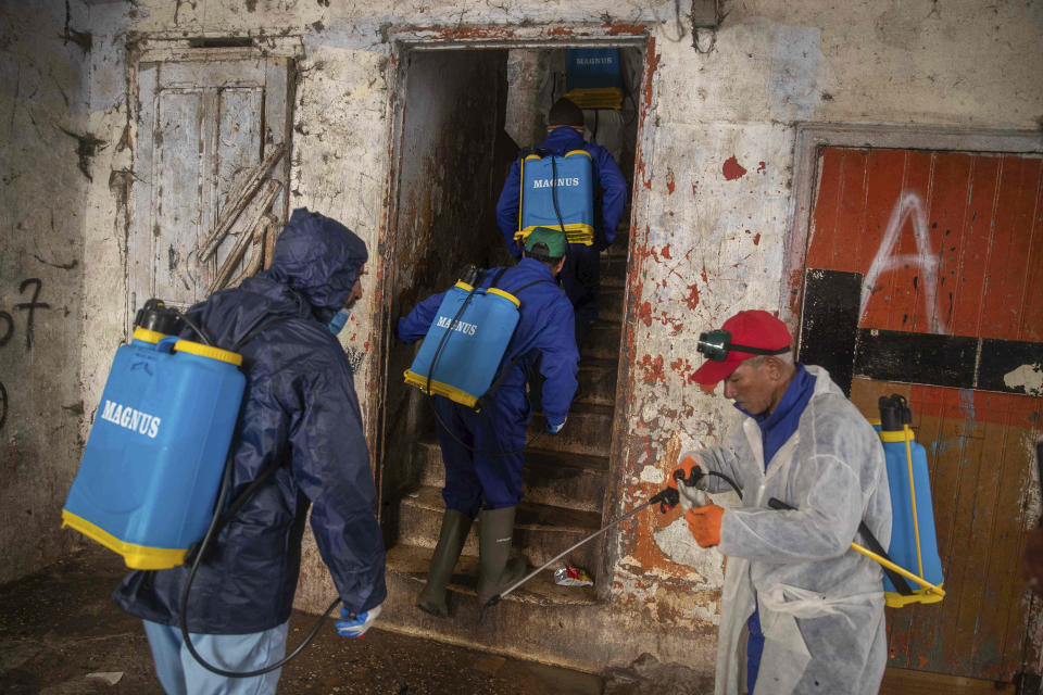 In this in Wednesday, March 25, 2020 photo, volunteers disinfect a housing complex to prevent the spread of coronavirus in Sale, near Rabat, Morocco. Hundreds of people live in crowded rooms in this Moroccan housing complex with no running water and no income left because of the coronavirus lockdown measures. However, volunteers come to help clean as the government tries to protect the population from virus while not punishing the poor. (AP Photo/Mosa'ab Elshamy)