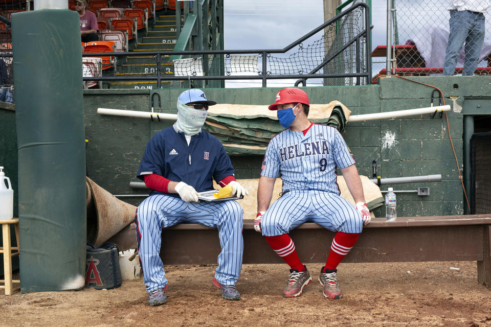 Helena Senators coaches Al Goebel (left) and Anthony Hogan talk near the dugout during the amateur baseball game against the Missoula Mavericks. (Photo by Janie Osborne/Getty Images)