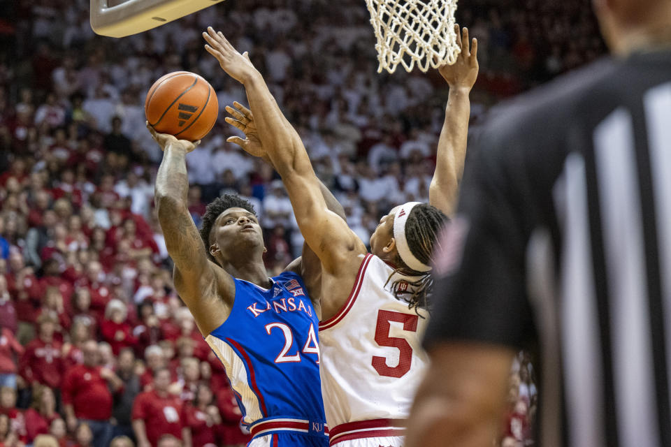 Kansas forward K.J. Adams Jr. (24) shoots while being defended by Indiana forward Malik Reneau (5) during the first half of an NCAA college basketball game, Saturday, Dec. 16, 2023, in Bloomington, Ind. (AP Photo/Doug McSchooler)