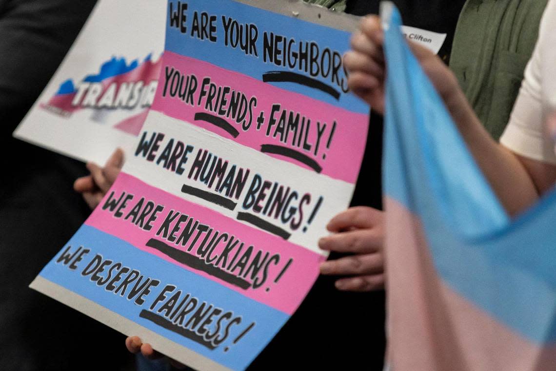 People hold signs while attending a LGBTQ rally in the rotunda at the Kentucky state Capitol in Frankfort, Ky., on Wednesday, Feb. 21, 2024.