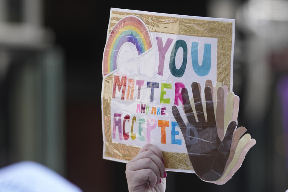 A participant holds up a sign while walking during the Pride Parade, Saturday, June 10, 2023, in Indianapolis. (AP Photo/Darron Cummings)