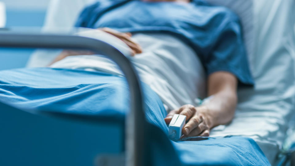 A patient lies in a hospital bed