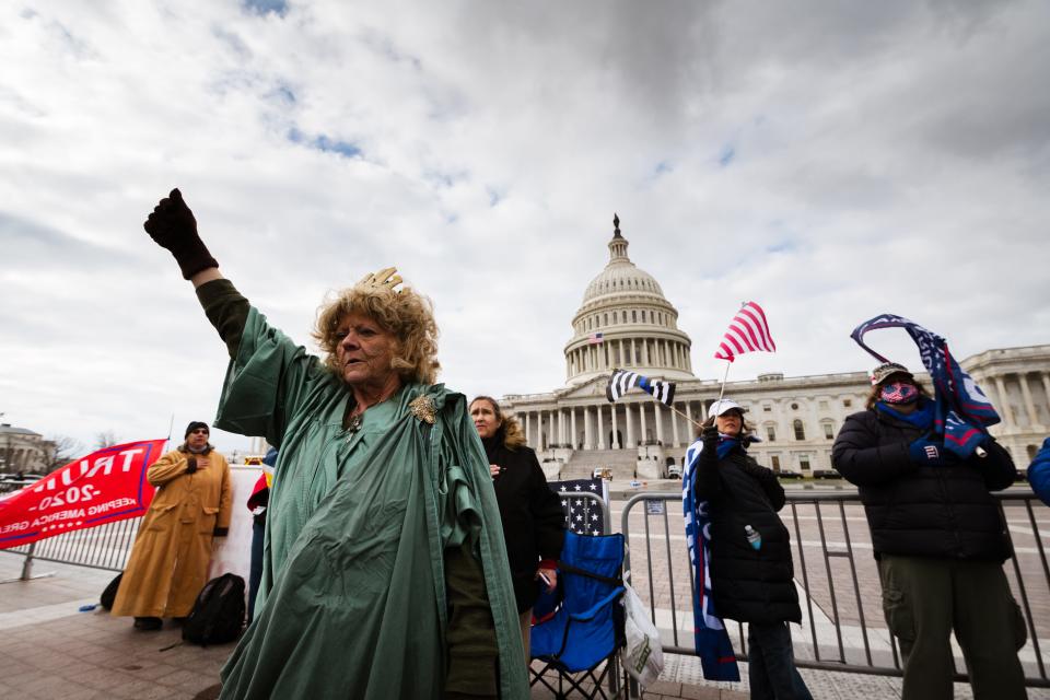 WASHINGTON, DC - JANUARY 06: A protester dressed like the Statue of Liberty stands with a fist raised on the grounds of the Capitol Building on January 6, 2021 in Washington, DC. A pro-Trump mob stormed the Capitol earlier, breaking windows and clashing with police officers. Trump supporters gathered in the nation's capital to protest the ratification of President-elect Joe Biden's Electoral College victory over President Donald Trump in the 2020 election. (Photo by Jon Cherry/Getty Images)