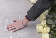 <p>A woman holds her hand on a plain metal plaque during a wreath-laying ceremony on occasion of the international Holocaust remembrance day in the former Nazi concentration camp Buchenwald near Weimar, Germany, Friday, Jan. 26, 2018. (Photo: Jens Meyer/AP) </p>