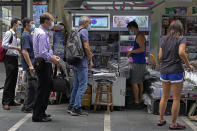 People queue up to buy Apple Daily at a downtown street in Hong Kong Friday, June 18, 2021. The pro-democracy paper increased its print run to 500,000 copies on Friday, a day after police arrested five top editors and executives and froze $2.3 million in assets linked to the media company. (AP Photo/Vincent Yu)