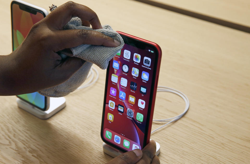 PARIS, FRANCE - NOVEMBER 15:  An employee cleans an iPhone Apple XR  during the press visit of the new Apple Store Champs-Elysees on November 15, 2018 in Paris, France. Apple will open its largest French store on the Avenue des Champs-Elysees in Paris this Sunday, November 18, 2018. This new store located in the heart of the capital is poised to become Apple's French flagship.   (Photo by Chesnot/Getty Images)