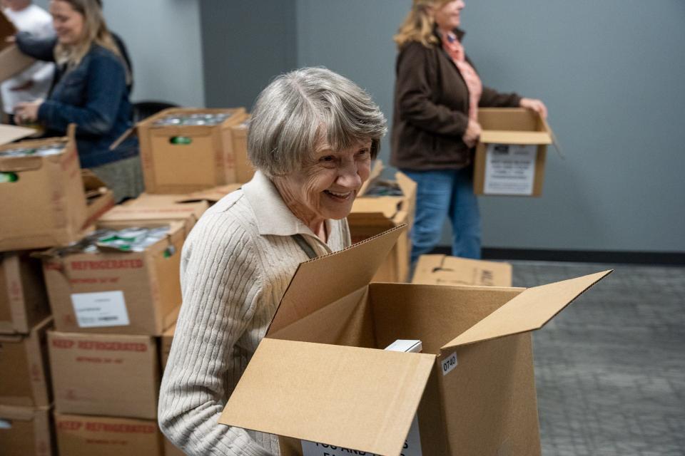 Volunteers come in all age ranges as Thera Carr does her part to pack boxes at the Feed the 5,000 packing party held at Grace Baptist Church Wednesday Nov. 17, 2021.