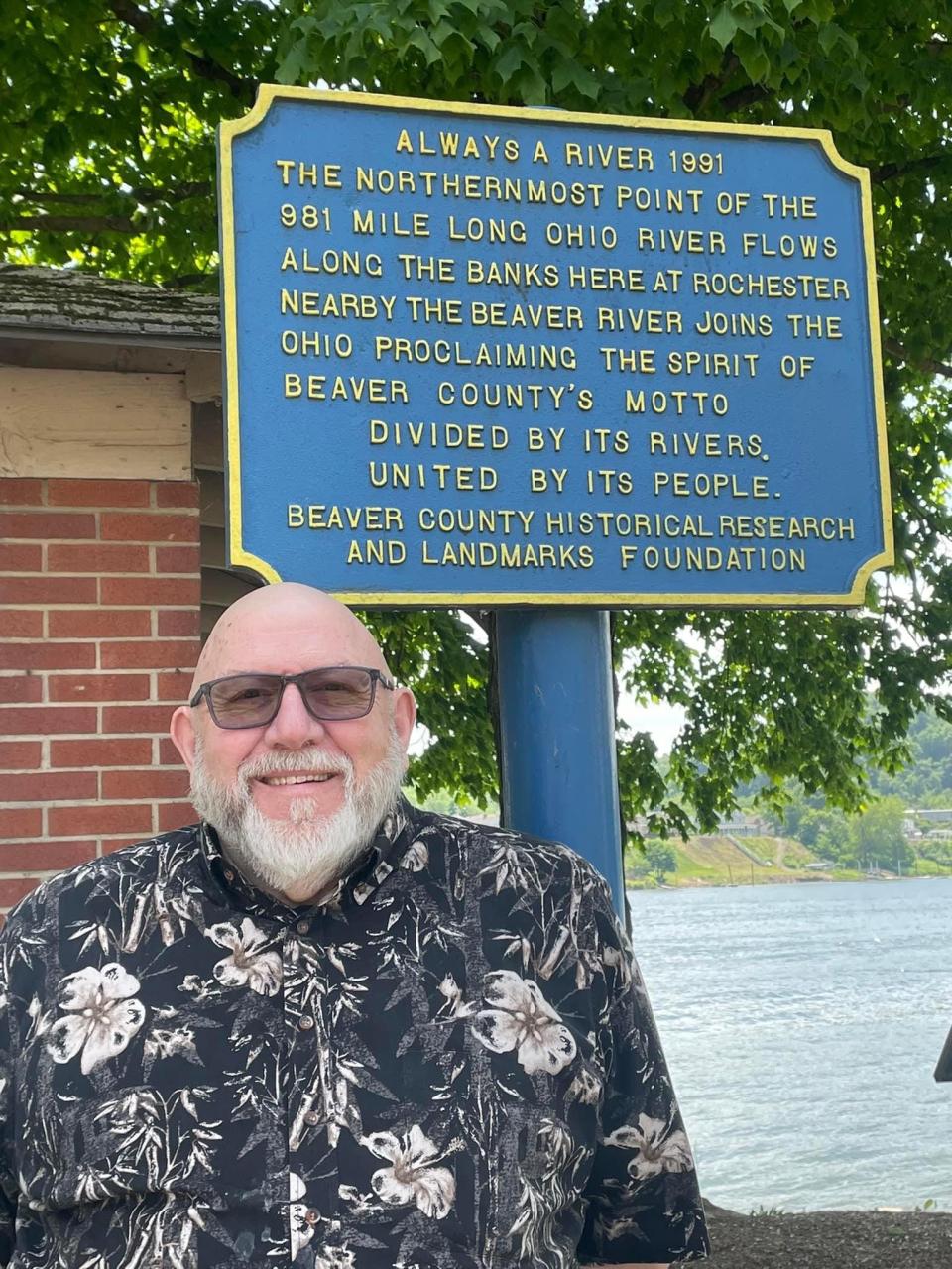 Barry Dawson at Rochester Riverfront Park this past Memorial Day weekend, posed with a sign bearing the Beaver County motto he conceived.