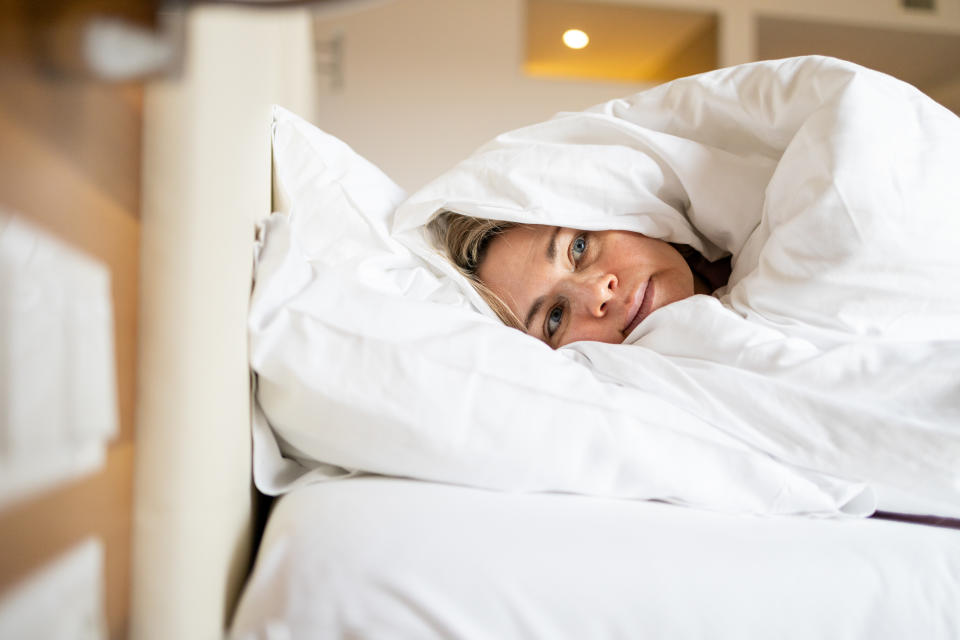 Mature woman in depression laying in bed covered with blanket. Melancholy mood, mental health, menopause Life problem. Insomnia and psychological issues.