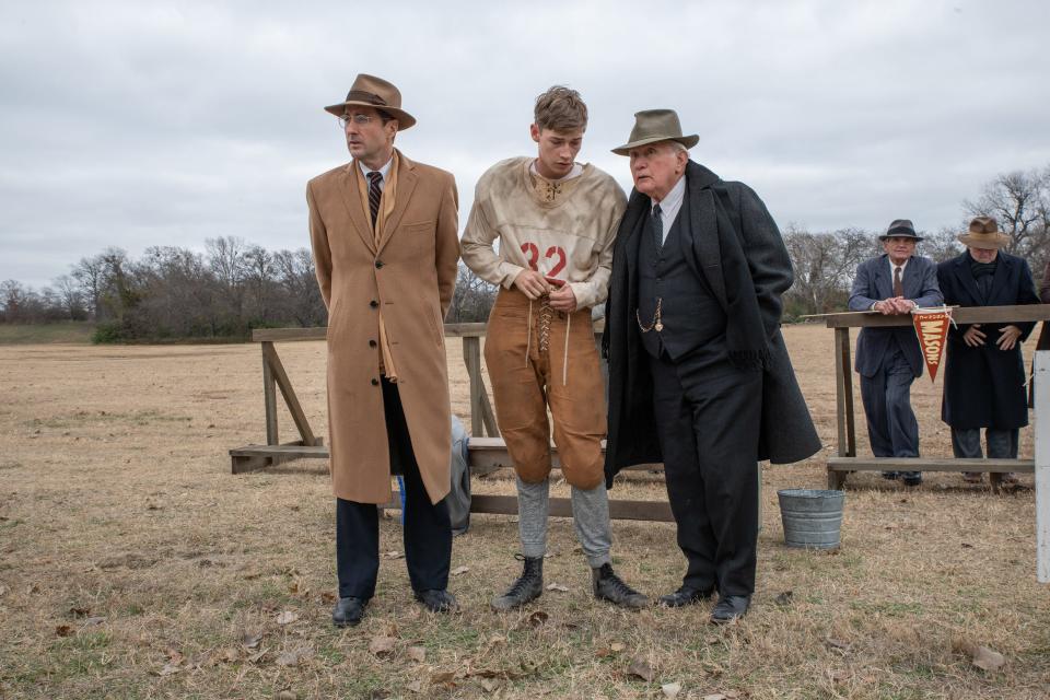 Rusty Russell (far left, Luke Wilson, far left), Snoggs (Jacob Lofland) and Doc Hall (Martin Sheen) discuss the next play in the football drama "12 Mighty Orphans," about an underdog team of scrawny orphaned Texan boys who become a winning squad.