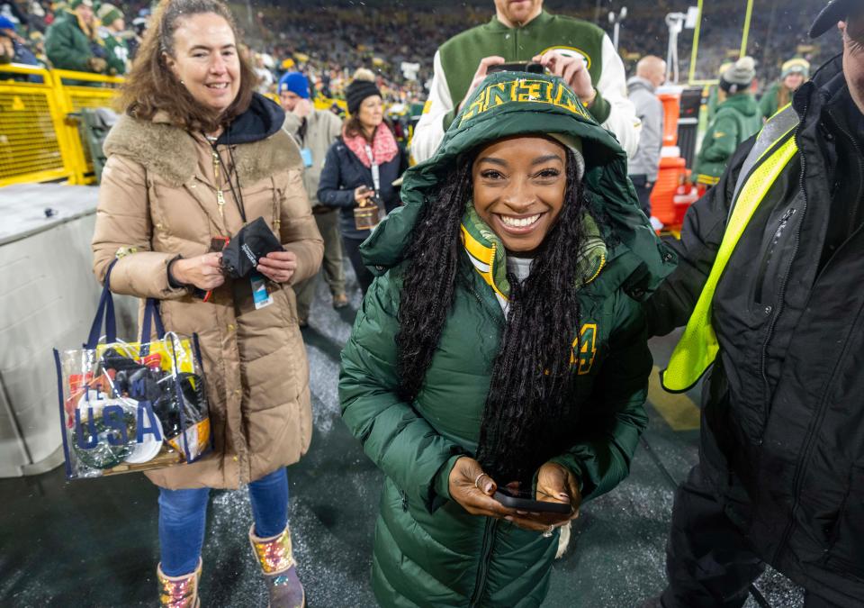 Simone Biles walks on the field before the Chiefs-Packers game at Lambeau Field.