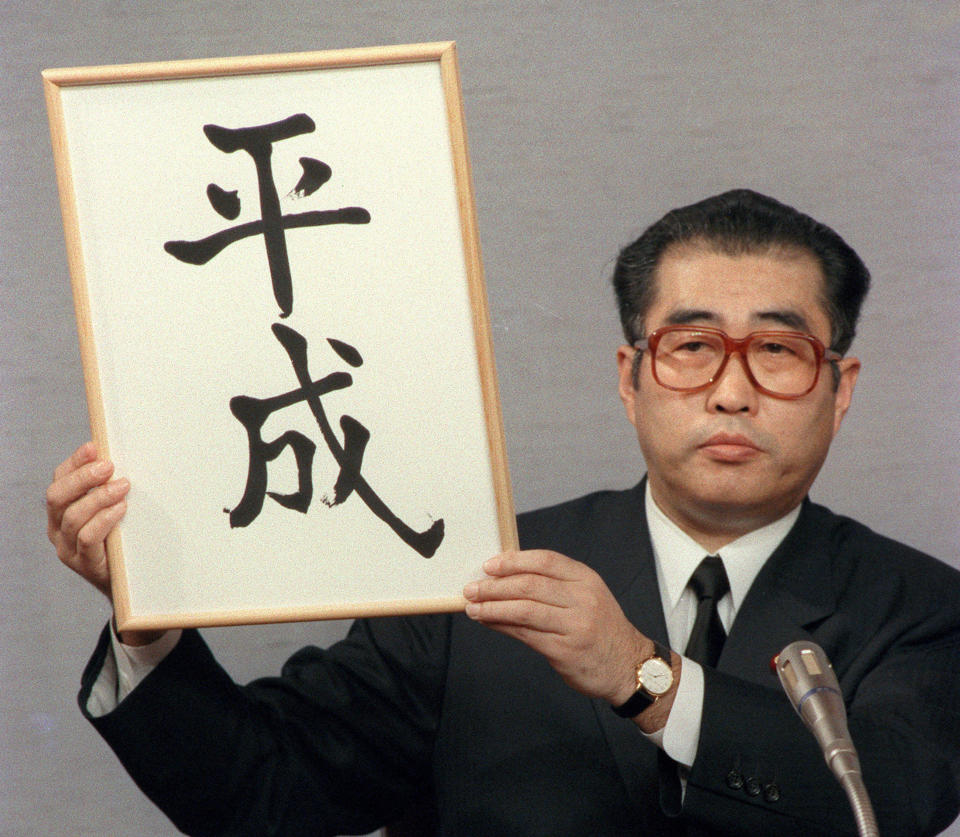 In this Jan. 7, 1989, photo, then Japan's Chief Cabinet Secretary Keizo Obuchi unveils the name of a new era "Heisei" during a press conference at the prime minister's official residence in Tokyo, following the death of Emperor Hirohito earlier that day. What’s in a name? Quite a lot if you’re a Japanese citizen awaiting the official announcement Monday. April 1, 2019 of what the soon-to-be-installed new emperor’s next era will be called. It’s a proclamation that has happened only twice in nearly a century, and the new name will follow Emperor Naruhito, after his May 1 investiture, for the duration of his rule, attaching itself to much of what happens in Japan.(Kyodo News via AP)