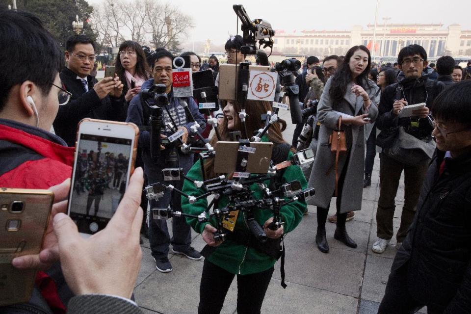 A journalist operate a harness with multiple recording devices capable of recording and live streaming outside the Great Hall of the People where the opening session of the Chinese People's Political Consultative Conference (CPPCC) was held in Beijing, China, Friday, March 3, 2017. Thousands of delegates have gathered at the Chinese capital for the opening of the annual session of the Chinese People's Political Consultative Conference, which advises the rubberstamp parliament, whose annual session begins Sunday. (AP Photo/Ng Han Guan)