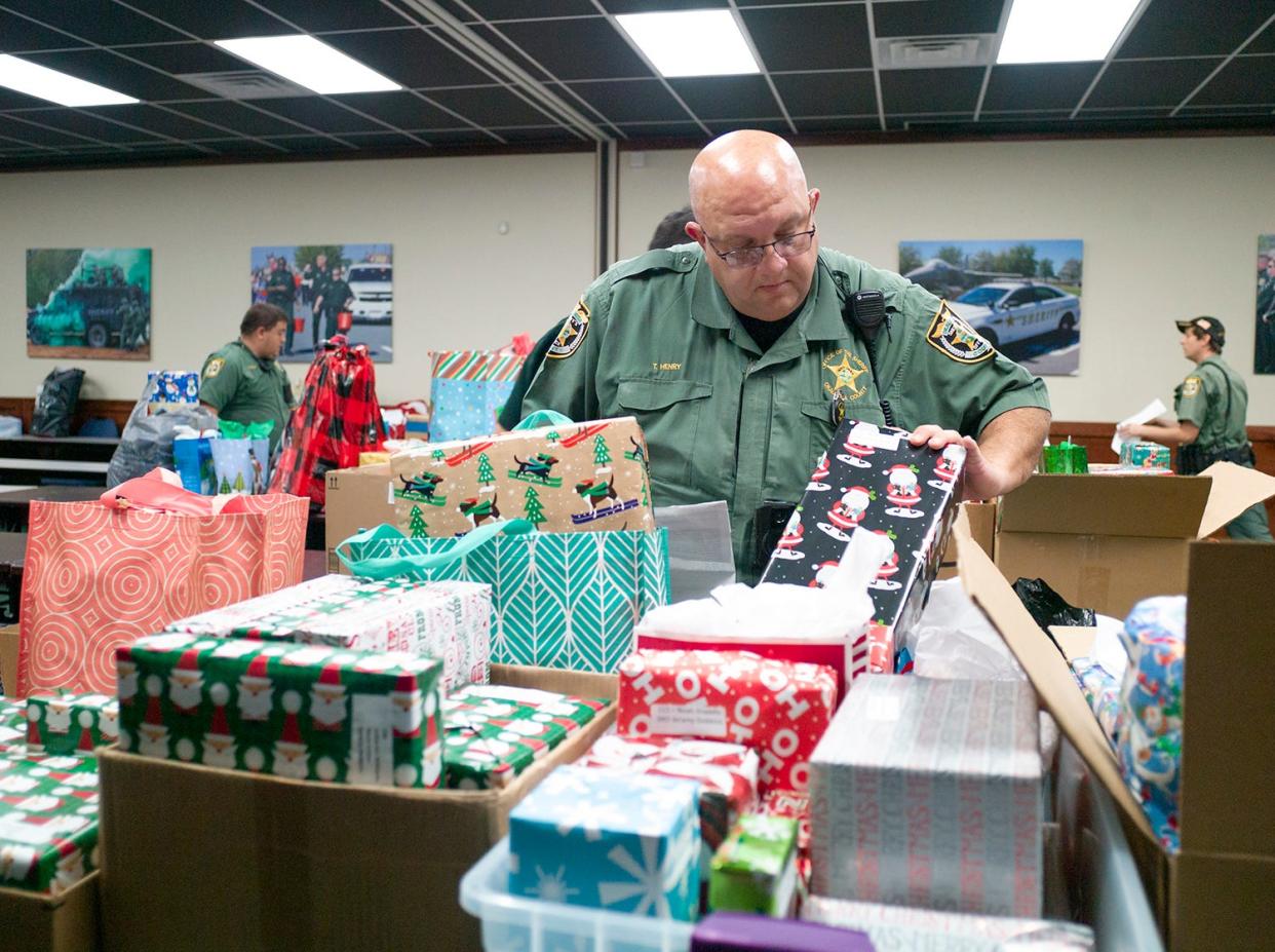 Deputy Tom Henry, the school resource officer at the new Destin High School, looks for his school's gifts during the Okaloosa County Sheriffs Office annual Angel Tree Toy Drive. The need is up significantly this year.