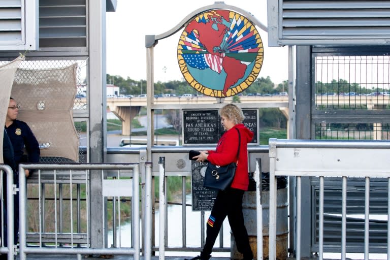 A pedestrian prepares to show her passport as she enters the United States from Mexico in Laredo, Texas