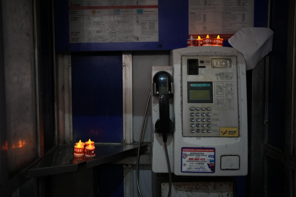 LED candles are displayed by a protester at a phone booth near the Hong Kong's Victoria Park, Saturday, June 4, 2022. Heavy police force patrolled Hong Kong's Victoria Park on Saturday after authorities for a third consecutive year banned public commemoration of the anniversary of the deadly Tiananmen Square crackdown in 1989, with vigils overseas the only place marking the event. (AP Photo/Kin Cheung)