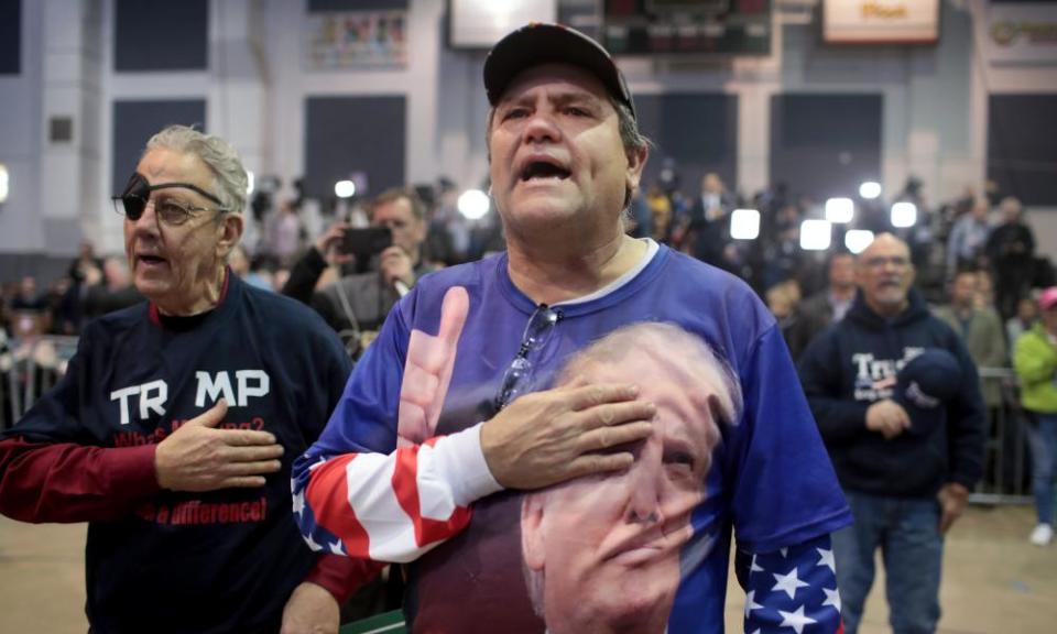 Supporters sing the national anthem during a rally hosted by Donald Trump at the Kellogg Arena.