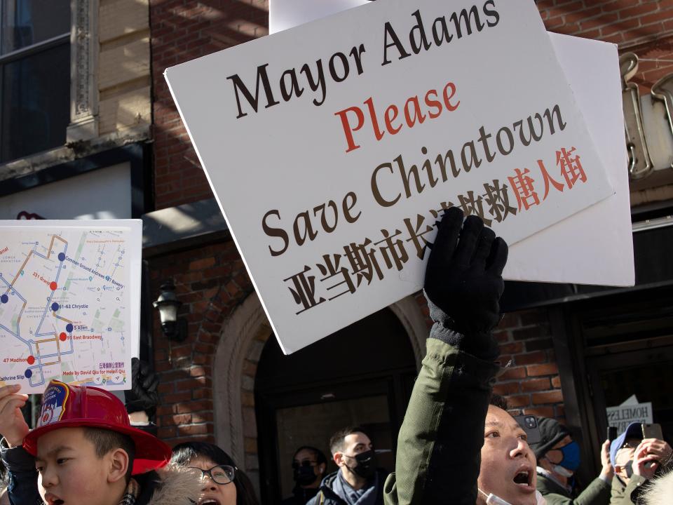 Chinatown residents protest against plans to build a new jail in the neighborhood, holding a placard that reads "Mayor Adams Please Save Chinatown"