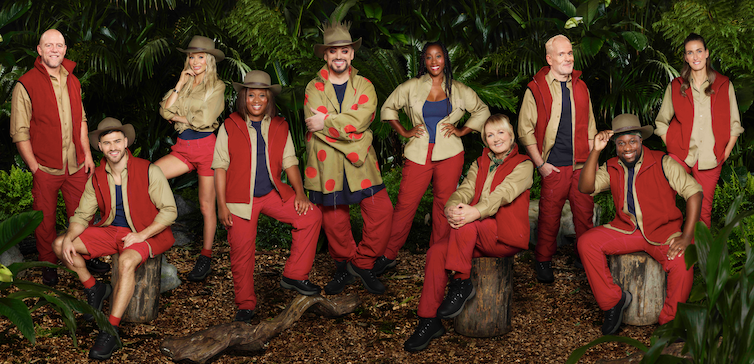 The ten contestants pose together in the jungle