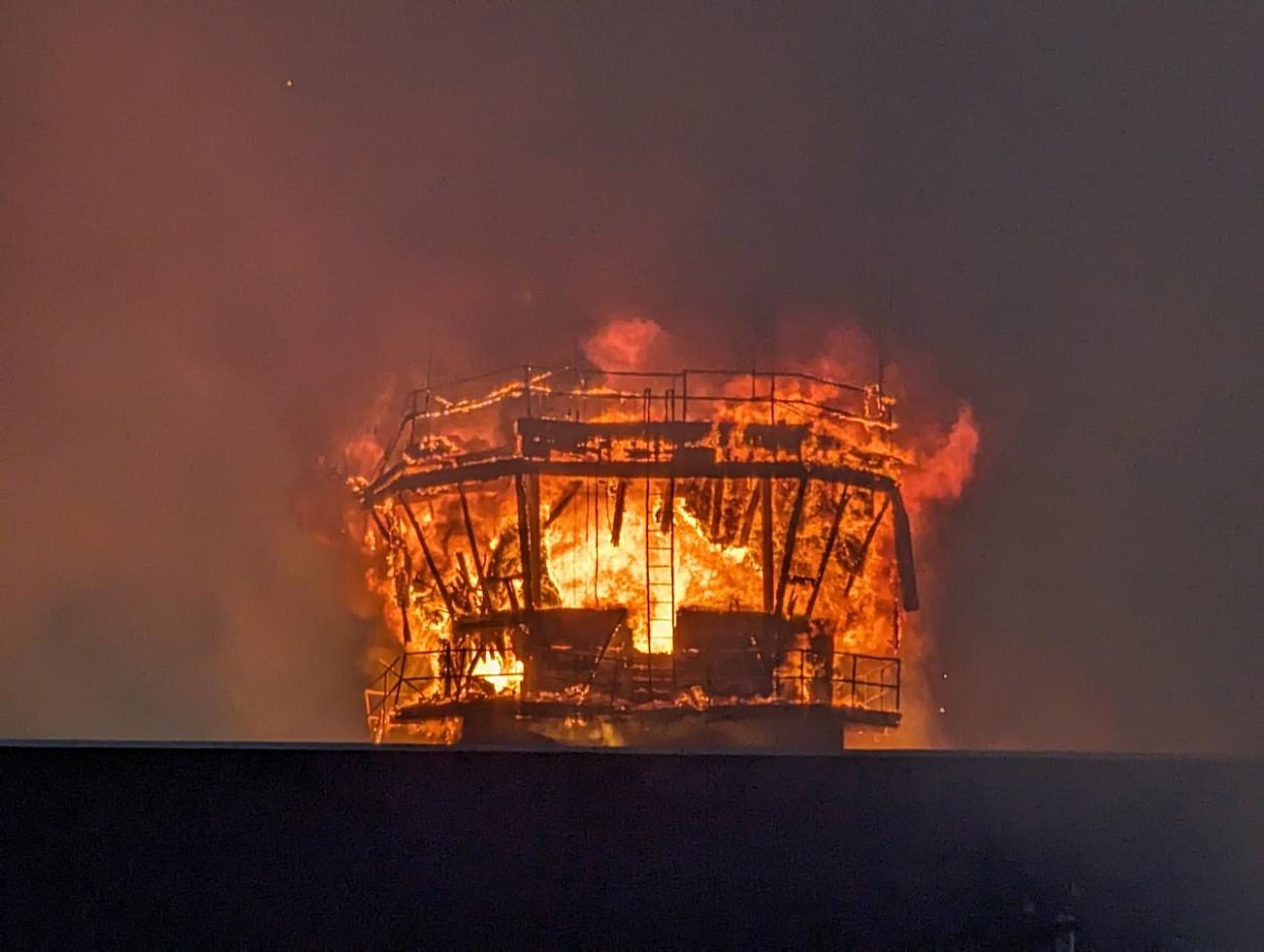 A fire burns Friday at the former airport tower and ceramics store in Happy Valley-Goose Bay, N.L.  (Heidi Atter/CBC - image credit)