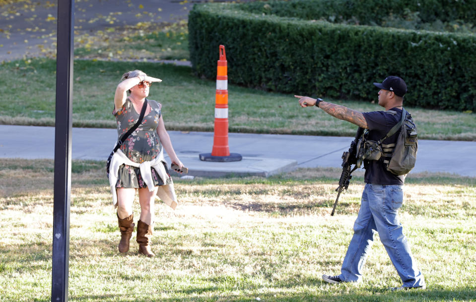 A woman is directed to leave the University of Nevada, Las Vegas, campus by a law enforcement officer after a fatal shooting on Wednesday, Dec. 6, 2023, in Las Vegas. (Steve Marcus/Las Vegas Sun via AP)