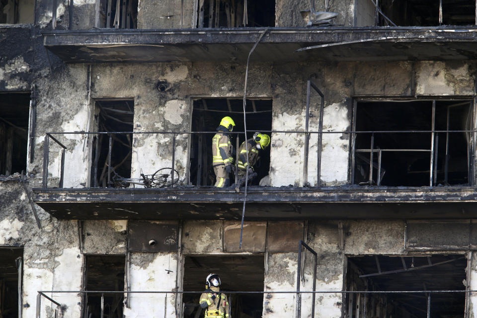 Firefighters remove a charred body inside a burned block building in Valencia, Spain, Friday, Feb. 23, 2024. As firefighters and scientific police began inspecting the interior of two residential towers that were destroyed by fire in the eastern Spanish city of Valencia, killing four people, questions abounded as to how the fire spread so rapidly. Authorities said 14 people were still missing following the blaze at the modern complex Thursday. (AP Photo/Alberto Saiz)