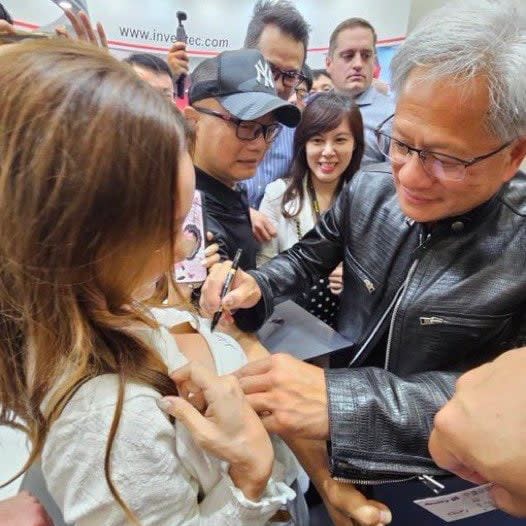 Jensen Huang signs a fan's chest