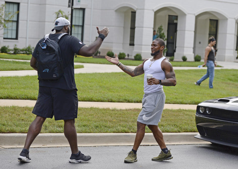 Carolina Panthers tackle Taylor Moton, left, and linebacker Denzel Perryman greet one another at NFL football training camp, Tuesday, July 27, 2021, at Wofford College in Spartanburg, S.C. (Jeff Siner/The Charlotte Observer via AP)