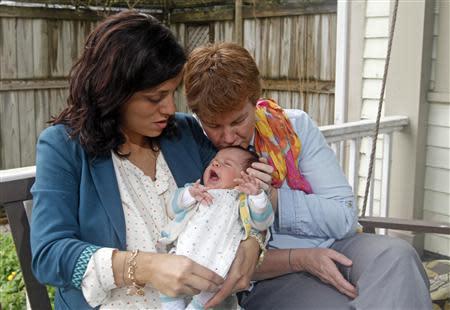 Valeria Tanco (L), and Sophy Jesty pose with their new baby girl, Emilia, at their home in Knoxville, Tennessee April 7, 2014. REUTERS/Wade Payne