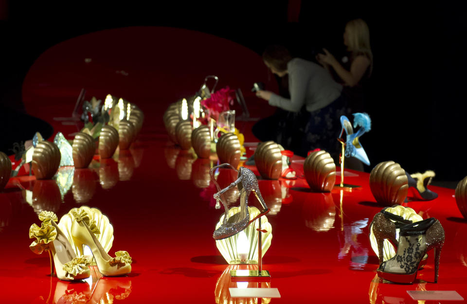 Members of the public photograph part of the first ever retrospective exhibition by French shoe designer, Christian Louboutin, at the Design Museum, London, Monday, April 30, 2012. The exhibition will be the first comprehensive presentation of Louboutin's work, and will showcase how he has helped transform the design of the shoe over the past 20 years. (AP Photo/Jonathan Short)