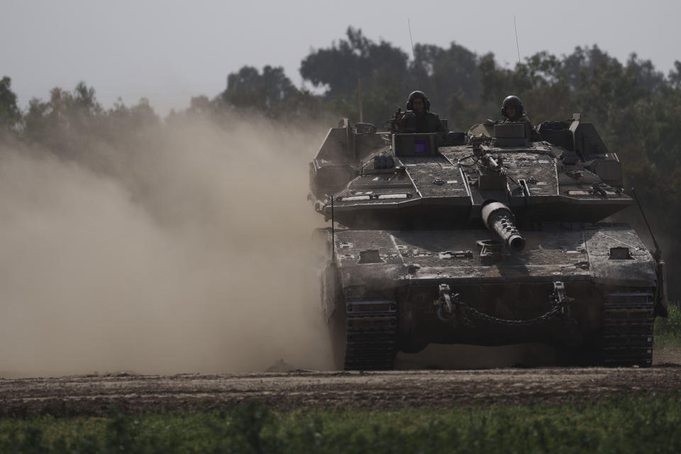 Israeli soldiers move on the top of a tank near the Israeli-Gaza border, as seen from southern Israel, Tuesday, Jan. 23, 2024. (AP Photo/Leo Correa)