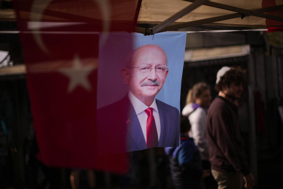 People walk past banners with the photograph of Turkish CHP party leader and Nation Alliance's presidential candidate Kemal Kilicdaroglu in Istanbul, Turkey, Tuesday, April 18, 2023. Turkey is heading toward presidential and parliamentary elections on Sunday May 14, 2023. (AP Photo/Francisco Seco)