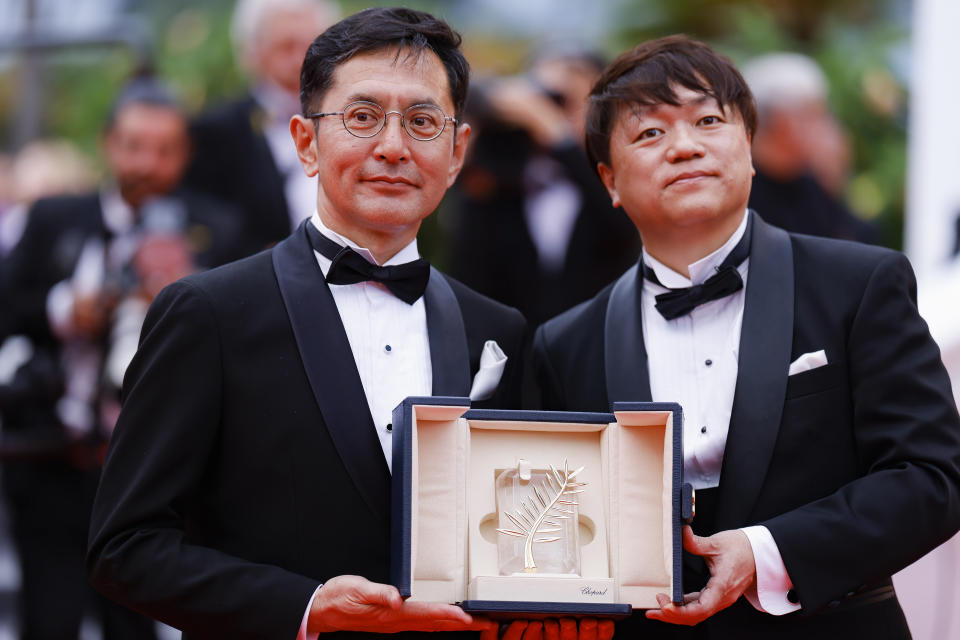 Goro Miyazaki, izquierda, y Kenichi Yoda posan con la palma de oro honoraria de Studio Ghibli en la 77a edición del Festival Internacional de Cine de Cannes en Francia el lunes 20 de mayo de 2024. (Foto Vianney Le Caer/Invision/AP)