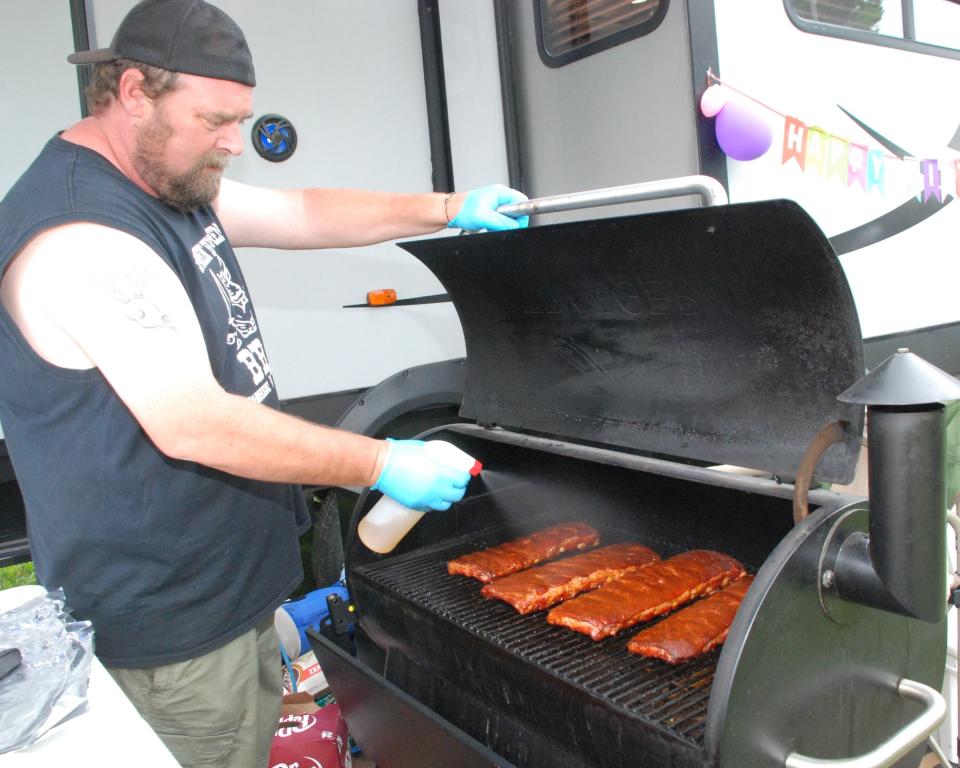 Mike Schilling of the Smokin Highwaymen barbecue team from Sobieski works on the ribs he has on the grill at the 2022 Death's Door Bar-B-Q contest on Washington Island. The Highwaymen are among 30 grilling teams from nine states that will be on the Island for this year's nationally sanctioned competitive event Aug. 25 through 27.
