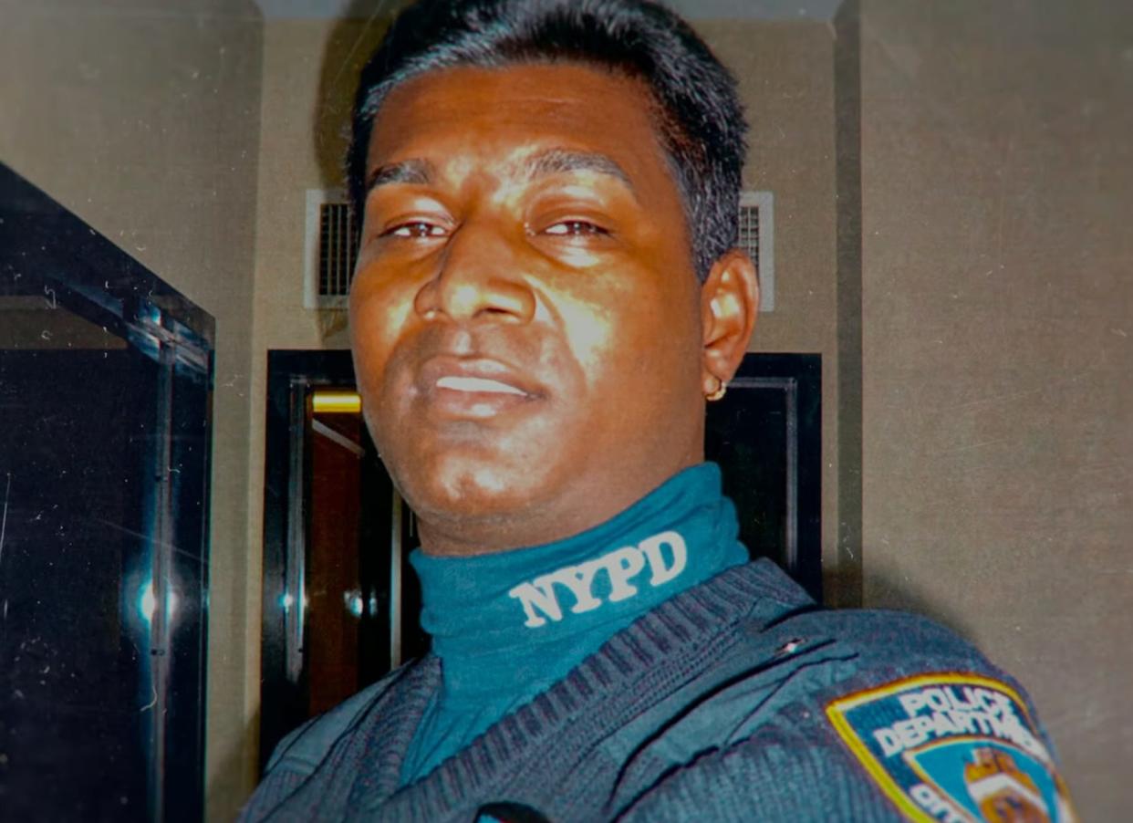 An Indian-American man with short black hair wearing a blue NYPD uniform.